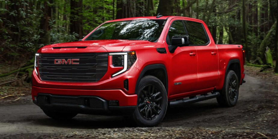 A red GMC Sierra parked on the street. 