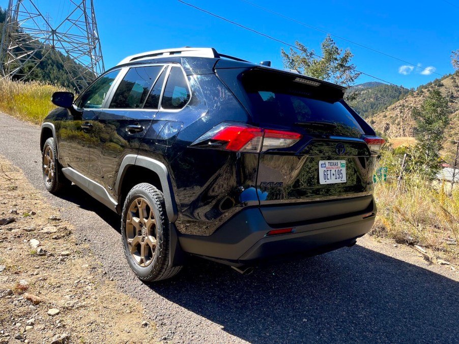 A rear corner view of the 2023 Toyota RAV4 Woodland Edition on a mountain road