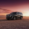 A 2023 Cadillac Escalade on display at a sunset.