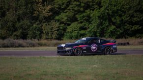 A black 2024 Ford Mustang Dark Horse on the track.