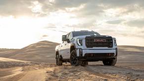 A 2024 GMC Sierra 2500 HD AT4 heavy-duty, all-terrain pickup truck model traversing a desert