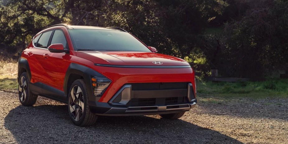 An orange 2024 Hyundai Kona subcompact SUV is parked. 