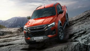 Red 2024 Isuzu D-Max EV pickup on rocks