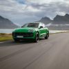 A green 2024 Porsche Macan driving down a scenic road.