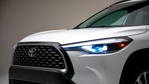 An exterior shot of the grille and headlights on a 2024 Toyota Corolla Cross subcompact SUV in Wind Chill Pearl