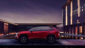 A red 2024 Toyota RAV4 Prime small plug-in hybrid SUV is parked.