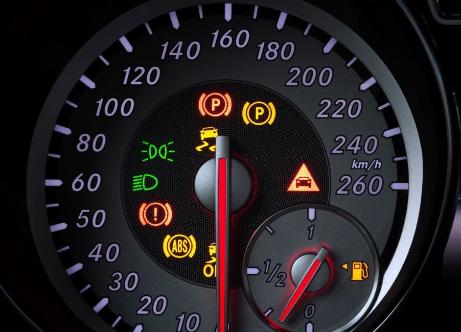 A car's speed display with illuminated warning lights, including the ABS (Anti-lock Brake System) light