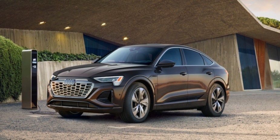 A black Audi e-tron midsize electric SUV from a side view. 