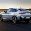 The BMW X4, the most satisfying compact luxury SUV, in gray driving down an empty road.