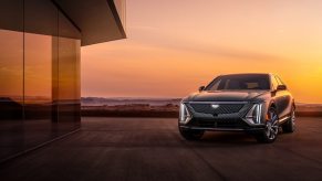 A dark Cadillac Lyriq parked in front of a window at twilight. Cadillac Lyriq sales are finally picking up.