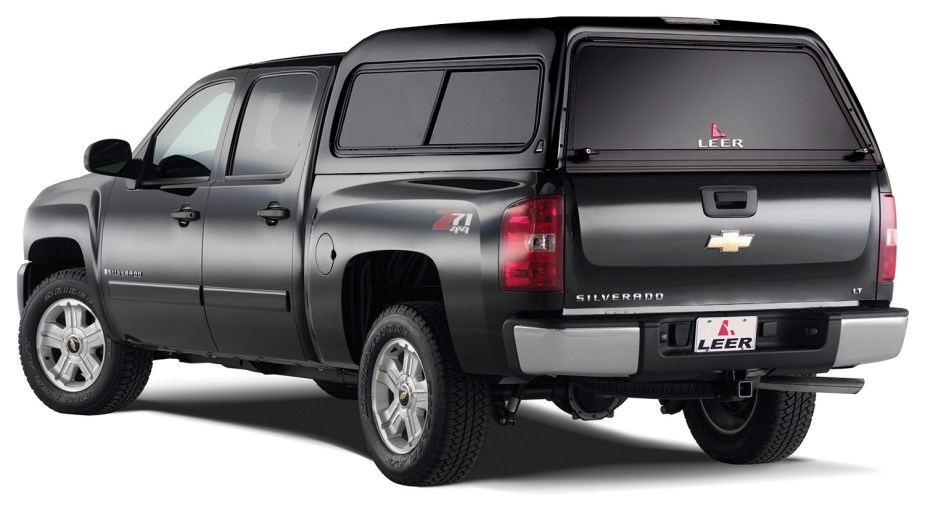 A black half-ton pickup truck with a camper shell cap.