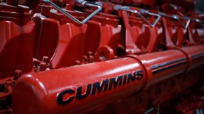 Closeup of the Cummins logo on a red diesel engine.