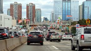 A series of daily driver cars, including compact AWD SUVs and cheap used cars, drive on the highway in New Jersey.