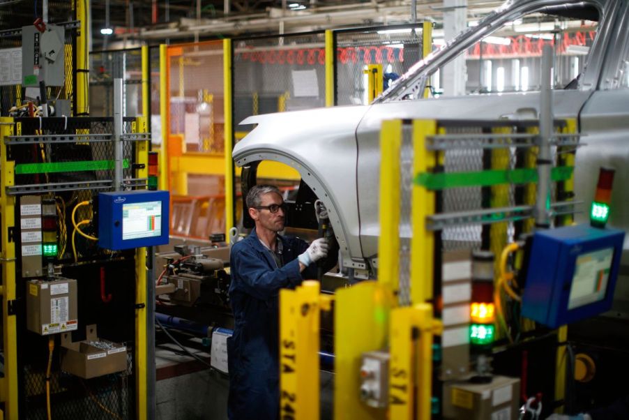 A worker assembling a luxury Lincoln car at a Ford factory.