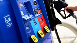 A person removes the nozel from a pump at a gas station on July 29, 2022 in Arlington, Virginia.