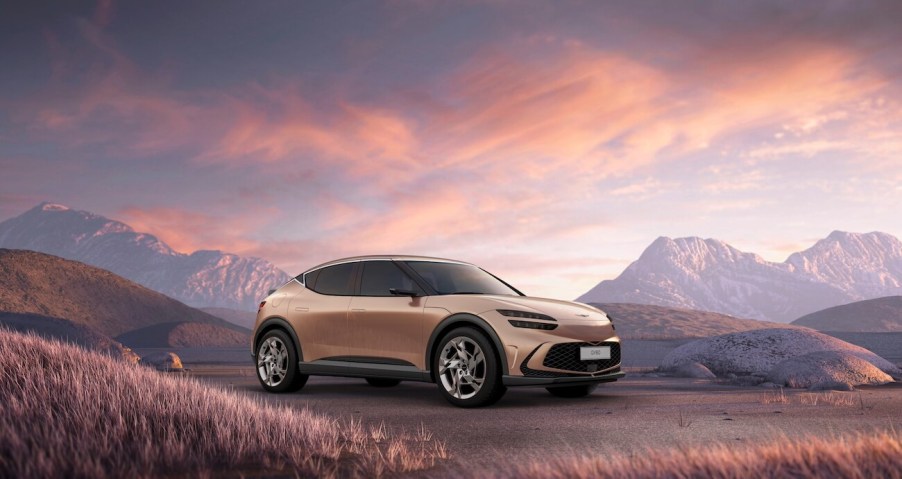 A copper Genesis GV60 with pink skies in the background at twilight. It's reportedly the most satisfying small luxury SUV.