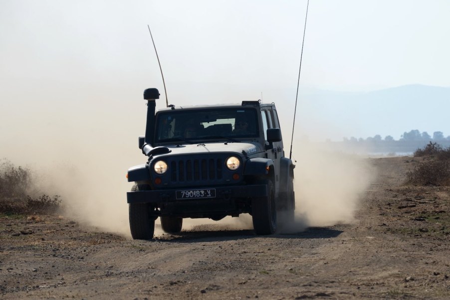 The Israeli Defense Force's military Jeep based on the Wrangler drives through the desert, a cloud of dust in the background.