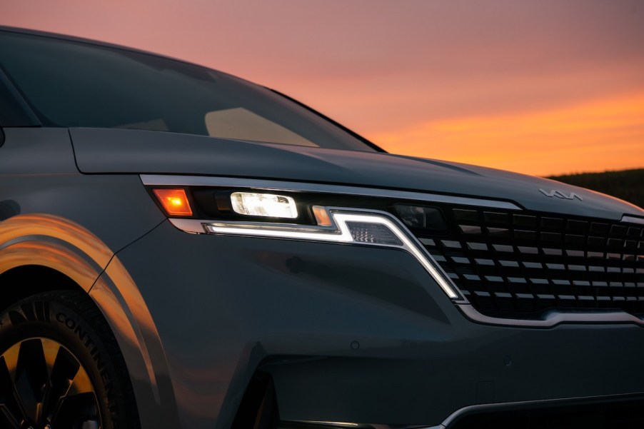 A close-up shot of the Kia Carnival at dusk. It's rated as the most satisfying minivan in 2023.