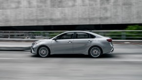 A 2023 Kia Forte driving down a city street.