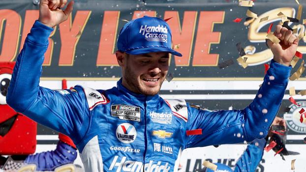 Kyle Larson celebrates with his arms raised