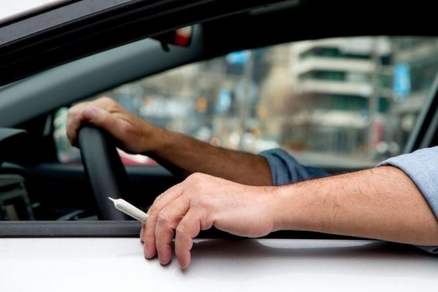 A person about to smoke marijuana and drive