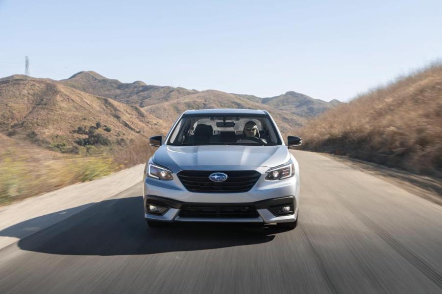 A Subaru Legacy driving down an open road.