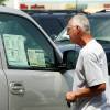 Man looking at vehicle window sticker