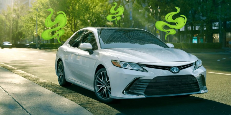 A white Toyota Camry midsize sedan is parked.