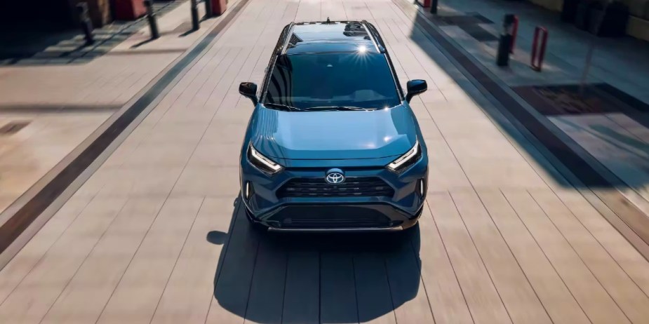 A blue 2024 Toyota RAV4 Hybrid small hybrid SUV is driving. 