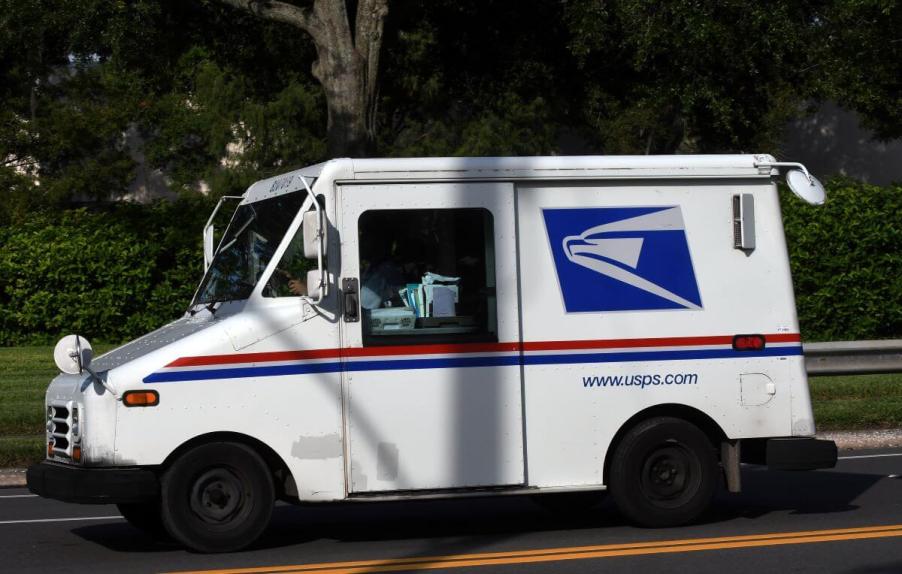 A USPS Grumman LLV delivery truck being driven by a mail carrier in Orlando, Florida