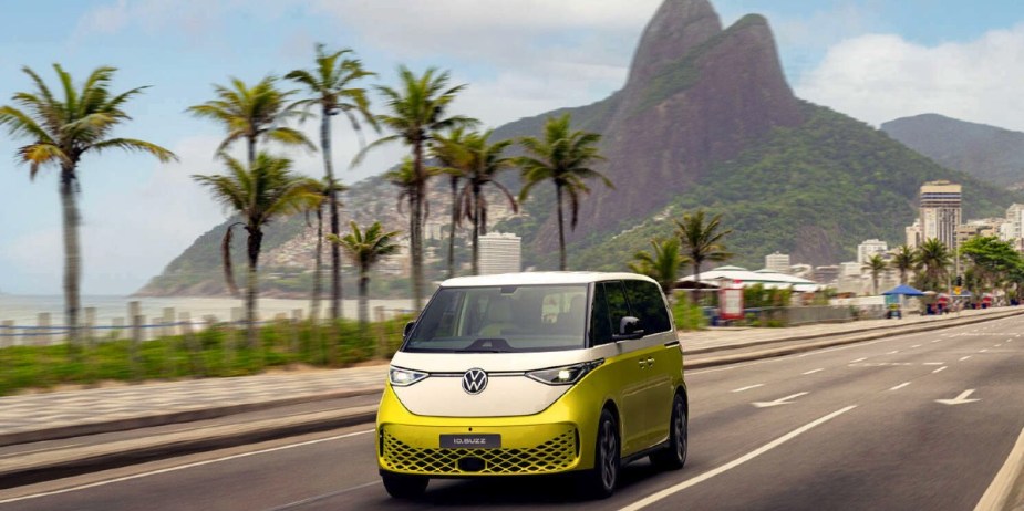 A green Volkswagen ID. Buzz electric microbus is driving on the road. 