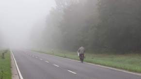 Haunted roads: A bicyclist rides on a foggy rural road