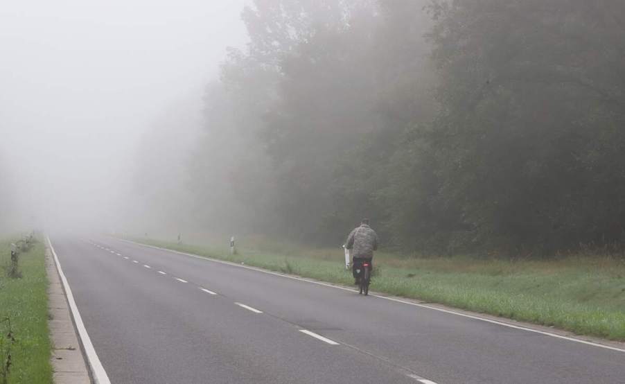 Haunted roads: A bicyclist rides on a foggy rural road