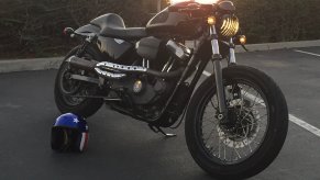 A black Harley-Davidson Sportster XL1200N shows off its custom work on a California beach.