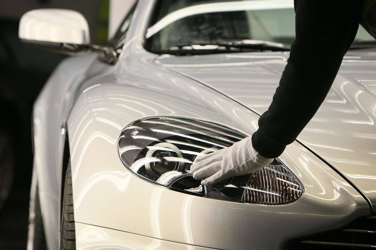 A factory worker polishes a headlight