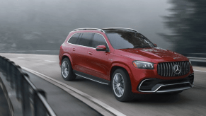 A 2024 Mercedes-Benz AMG-GLS SUV full-size luxury SUV driving on a twisting, foggy highway road