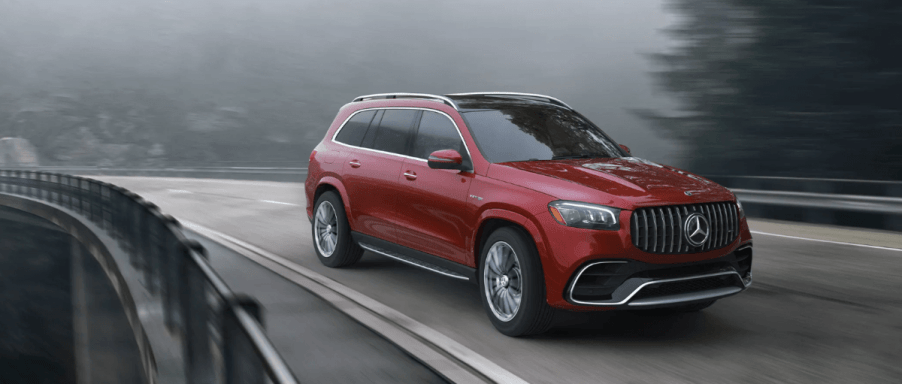 A 2024 Mercedes-Benz AMG-GLS SUV full-size luxury SUV driving on a twisting, foggy highway road