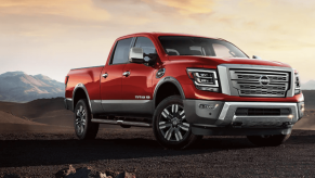 A 2024 Nissan Titan XD heavy-duty pickup truck model parked on a dirt plain near hills and under clouds