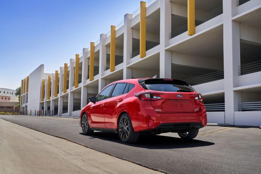 A rear shot of a 2024 Subaru Impreza RS all-wheel drive (AWD) hatchback model near a parking garage