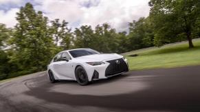 A 2024 Lexus IS 350 F Sport compact executive car model cornering in a park