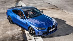 Overhead shot of blue 2023 BMW M4 parked on a racetrack.