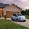 A white Chevy Bolt parked outside of a suburban house. Chevy Bolt complaints are pretty prevalent.