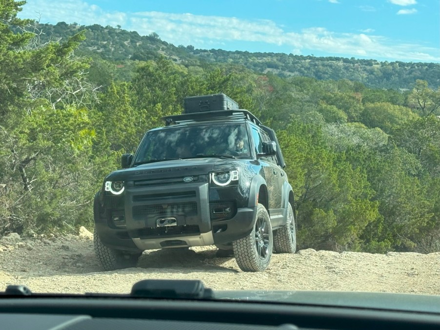 The 2023 Land Rover Defender 130 off-roading over rocky terrain