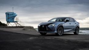 A 2023 Lexus RZ 450e Luxury all-electric SUV model in Ether Black parked on an overcast beach