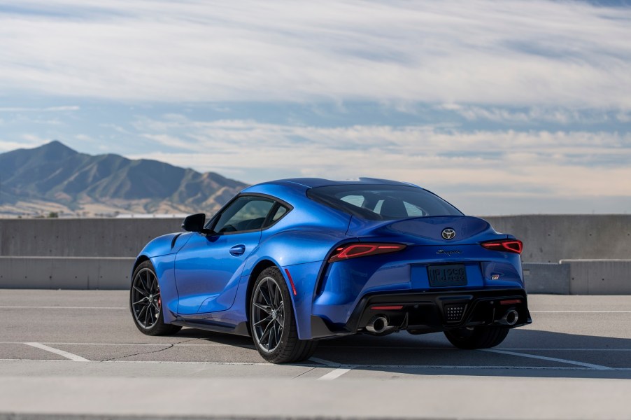 A blue 2023 Toyota Supra parked outside in left rear quarter view with a mountain in the background