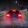 A new 2024 Ford Mustang Dark Horse in a dark tunnel with rear lights illuminated.