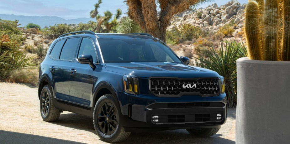 A blue 2024 Kia Telluride midsize three-row SUV is parked outdoors. 