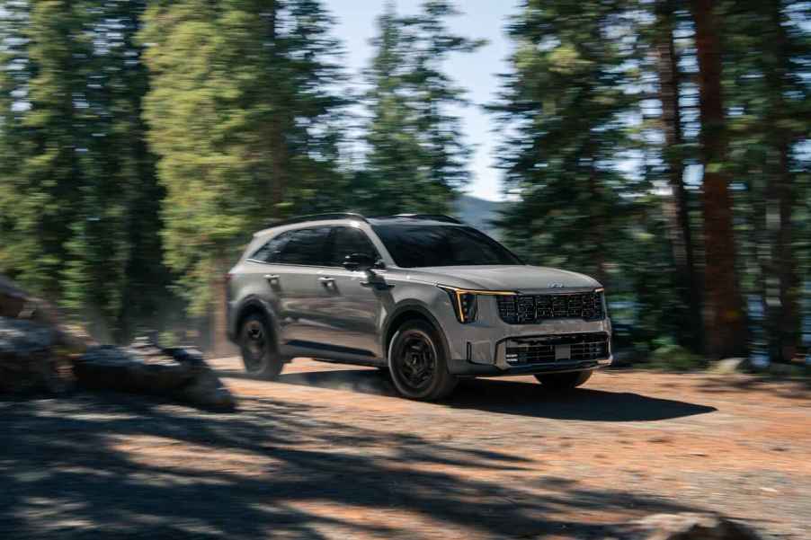 A grey 2024 Kia Sorento with a mid-cycle facelift driving in the woods