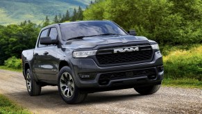 A Ramcharger hybrid pickup truck driving along a dirt road.