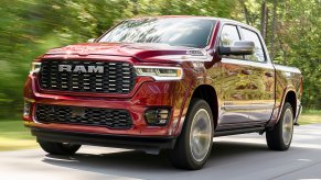 Red Ram 1500 pickup truck driving down the road.